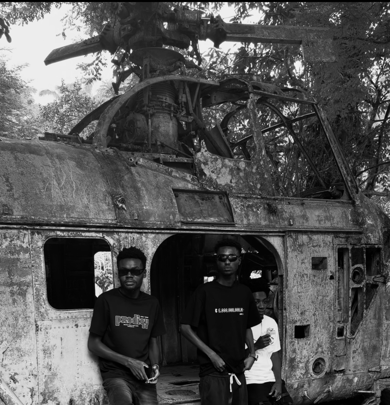 Three people wearing KROME-01 beside a damaged helicopter
